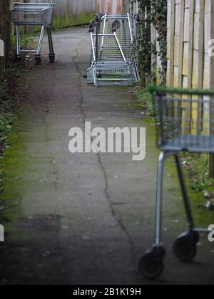 Carrelli per lo shopping scaricati in vicolo / passerella Foto Stock