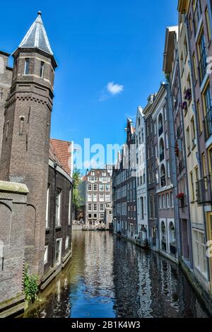 Amsterdam, Paesi Bassi - 22 Giugno 2016. Vista sul canale di Oudezijds Achterburgwal nel quartiere De Wallen nel centro di Amsterdam. Vista con residenza Foto Stock