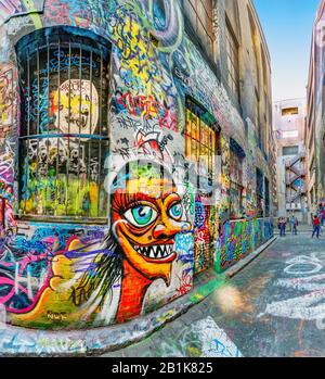 Divertenti graffiti viso dipinti su pareti di mattoni lungo un vicolo pieno di graffiti colorati, Hosier Street, Melbourne Lanes, Melbourne, Victoria, Australia Foto Stock