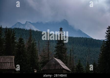 Percorso attraverso la Valle di Gasienicowa nelle montagne di Tatra, Polonia. Maltempo autunno su belle case di legno nei prati ai piedi delle colline. Foto Stock