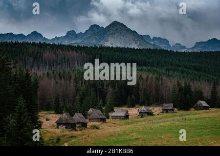 Percorso attraverso la Valle di Gasienicowa nelle montagne di Tatra, Polonia. Maltempo autunno su belle case di legno nei prati ai piedi delle colline. Foto Stock