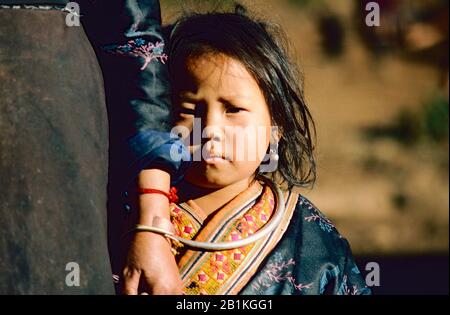 Bella ragazza giovane di Hmong / Miao Tribe nel nord della Thailandia indossando abito tradizionale e tenendo la mano delle madri. Foto Stock