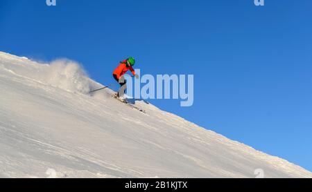 Sciatore femmina scendendo ripida pendenza pendenza nero, montagne dietro, SkiWelt Wilder Kaiser, Brixen im Thale, Tirolo, Austria Foto Stock