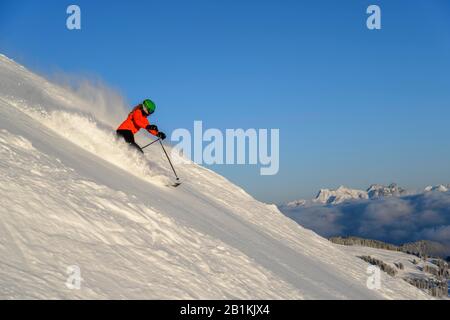 Sciatore femmina scendendo ripida pendenza pendenza nero, montagne dietro, SkiWelt Wilder Kaiser, Brixen im Thale, Tirolo, Austria Foto Stock