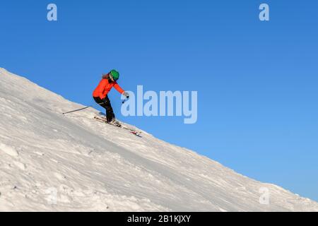 Sciatore femmina scendendo ripida pendenza pendenza nero, montagne dietro, SkiWelt Wilder Kaiser, Brixen im Thale, Tirolo, Austria Foto Stock