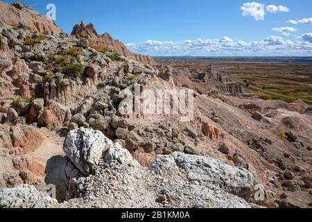 SD00209-00...SOUTH DAKOTA - rocce più Dure che cadono lungo la ripida collina, mentre la roccia sotto di loro cade a Saddle Pass in Badlands Natl. P. Foto Stock