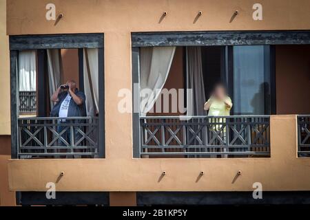 Tenero, Spagna. 26th Feb, 2020. Gli ospiti dell'hotel si trovano sui balconi dell'Hotel H10 Costa Adeje Palace a Tenerife. L'hotel di Tenerife, che è stato messo in quarantena a causa di casi di coronavirus, continua ad essere condonato dalla polizia. Credito: Arturo Rodríguez/dpa - solo per l'uso in conformità con accordo contrattuale/dpa/Alamy Live News Foto Stock