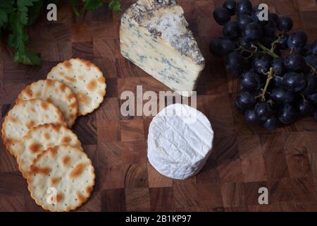Una selezione di formaggi, uva, cracker e coriandolo fresco Foto Stock