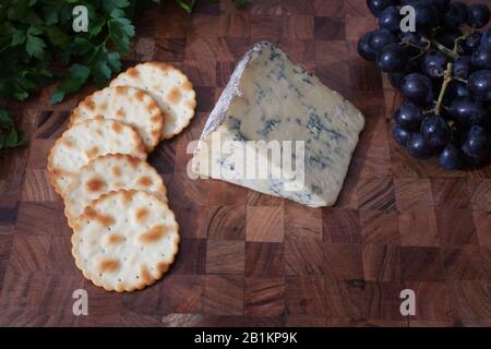 Una selezione di formaggi, uva, cracker e coriandolo fresco Foto Stock