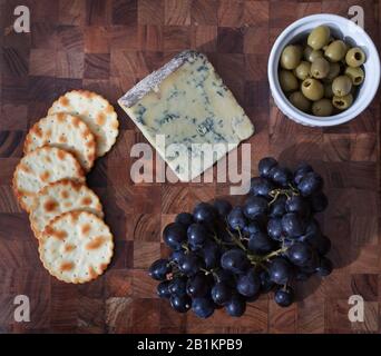 Una selezione di formaggi, uva, cracker e olive verdi Foto Stock