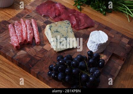 Una selezione di salumi, formaggi e uve Foto Stock