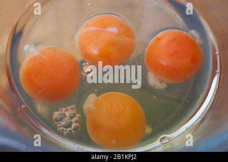 4 uova crude pronte per essere sbattite Foto Stock