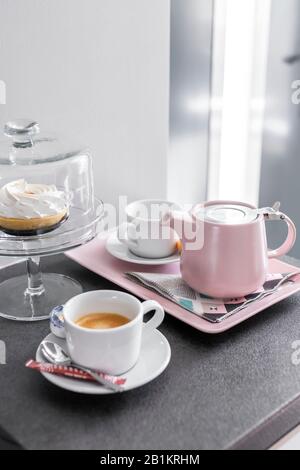 Budapest, Ungheria - 18 aprile 2019: Piatto da caffè e tazze da preparare su un vassoio e torta da dessert in un ambiente luminoso e chiaro. Foto Stock