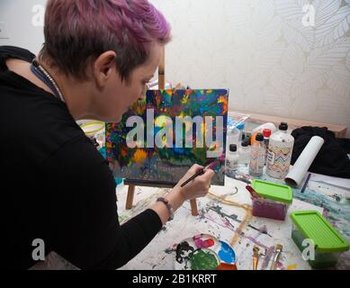 Un artista che dipinge un quadro astratto nel suo studio Foto Stock