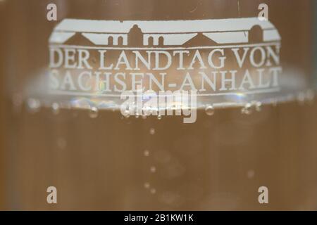 26 febbraio 2020, Sassonia-Anhalt, Magdeburg: La scritta "der Landtag von Sachsen-Anhalt" e un segno dell'edificio Landtag possono essere visti su un bicchiere d'acqua che è posto sulla scrivania dell'oratore e in cui le bolle si alzano. Nella 94th sessione, i deputati discuteranno il progetto di legge per la riforma parlamentare 2020. Foto: Klaus-Dietmar Gabbert/dpa-Zentralbild/dpa Foto Stock