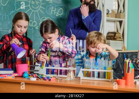 Cura e sviluppo dei bambini. Classi scolastiche. I bambini adorabili amici divertirsi a scuola. Concetto di laboratorio di chimica scolastica. Programma di sviluppo professionale per insegnanti basato su Practicum. Conoscenza pratica. Foto Stock