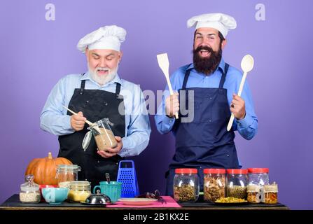 Insegnare cibo da cucina. Ingredienti naturali. Ricetta deliziosa. Chef uomini di cucina. Il team della cucina prepara il cibo. Cibo sano. Uomini maturi bearded cucina ristorante professionale. Concetto di tradizione familiare. Foto Stock