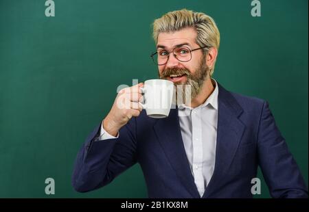 Concetto di ottimismo. Piacevole sorso. Pausa caffè e relax. Pranzo per insegnante. Dipendenza dal caffè. Carica di energia per tutto il giorno. Dose di caffeina. Insegnante in bicchieri bere caffè chalkboard sfondo. Foto Stock
