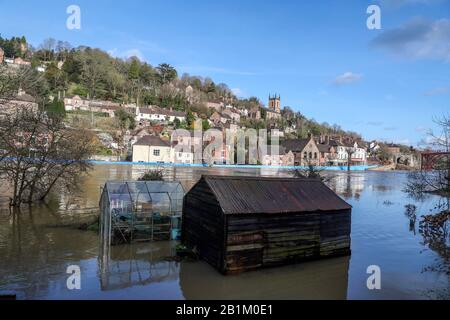 Dopo l'inondazione, il fiume Severn rimane ad alti livelli in Ironbridge, Shropshire, con alcuni giardini ancora sott'acqua. Foto Stock