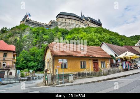 Karlstejn, Repubblica Ceca – 12 Luglio 2016. Vista sulla strada nella città del mercato di Karlstejn nella Repubblica Ceca, con il castello medievale di Karlstejn sullo sfondo. Foto Stock