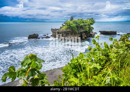 Vista di Tanah Lot, una formazione rocciosa al largo dell'isola indonesiana di Bali, sede di un antico tempio di pellegrinaggio indù pura Tanah Lot, Bali, Indonesia Foto Stock