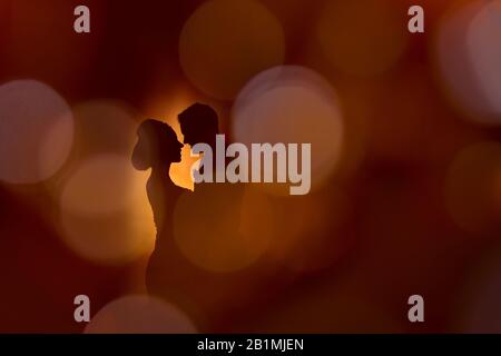 Silhouette sposa e sposo per matrimoni con sfondo arancione e sfumatura circolare Foto Stock