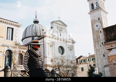 Venezia, Italia - Febbraio 9th - 2018: Gondoliere pensieroso in attesa dei turisti sul ponte Foto Stock