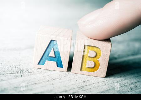 Possibilità A e B su blocchi di legno su un tavolo, UN dito tocca il blocco A Foto Stock