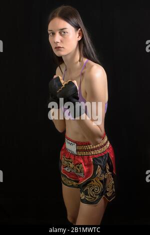 Ragazza pugile tedesca con pantaloni da boxe thai rossi e short top. Foto di scorta gratuita. Foto Stock