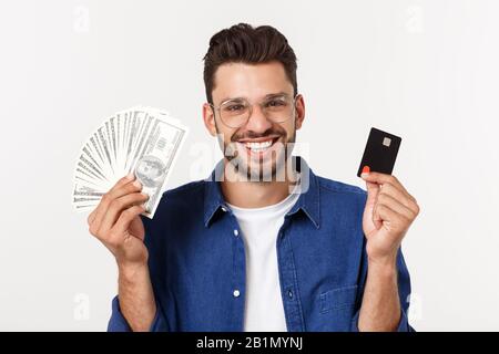 Ritratto di un uomo frinedly bearded che tiene la carta di credito e che mostra i contanti isolati su sfondo bianco Foto Stock