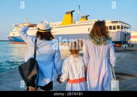 Vacanza in famiglia insieme, madre e due figlie in porto vicino al traghetto Foto Stock