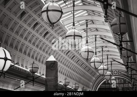 Lampade in stile neoclassico e soffitto a cassettoni ad arco di una galleria coperta Foto Stock