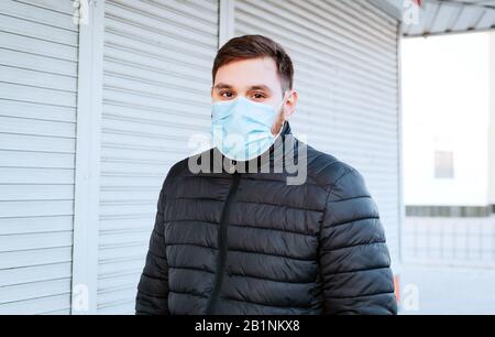 Coronavirus europeo. Ritratto di uomo caucasico che indossa maschera igienica facciale, maschera di protezione respiratoria all'aperto. Virus, protezione del coronavirus, aria Foto Stock