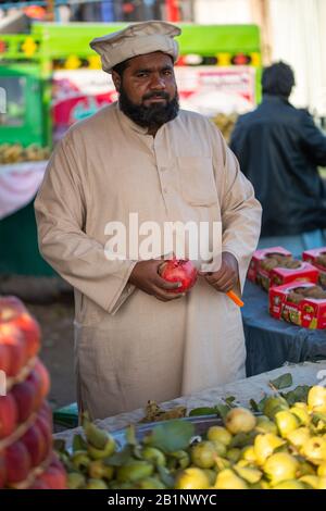 Islamabad, Islamabad Capital Territory, Pakistan - 3 febbraio 2020, UN venditore attende i clienti nel mercato vegetale per vendere frutta arancione. Foto Stock