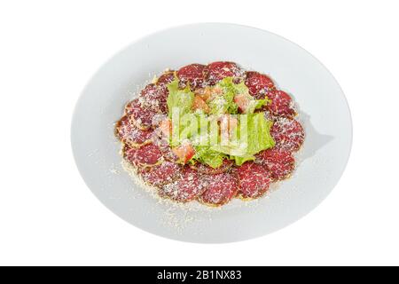 Antipasto freddo prima di alcol, cibo, arrosto di manzo marinato, fritto, manzo, con pomodoro, lattuga e formaggio grattugiato su piatto, bianco isolato fondo Sid Foto Stock