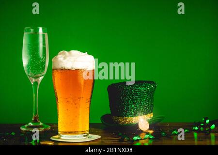 Concetto di festa di San Patrizio giorno con bicchiere di birra, champagne, cappello di leprechaun e monete d'oro sul tavolo - feste e celebrazioni conc Foto Stock