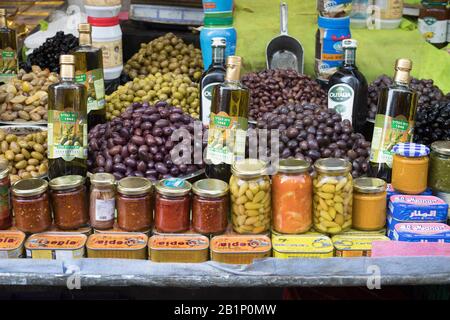 Olive, olio d'oliva e condimenti in vendita al Carmel Market (Shuk Hacarmel), il più grande mercato di Tel Aviv, Israele Foto Stock