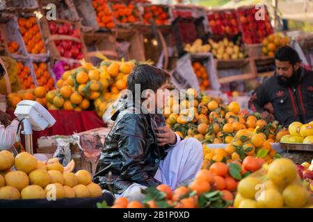 Islamabad, Islamabad Capital Territory, Pakistan - 3 febbraio 2020, UN giovane venditore attende i clienti Nel mercato Della Frutta per vendere i frutti. Foto Stock