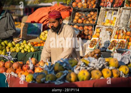 Islamabad, Islamabad Capital Territory, Pakistan - February 02, 2020, A seller is waiting for customers in the vegetable market to sell orange fruits. Foto Stock