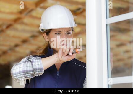 costruttore femminile che lavora sulla finestra Foto Stock
