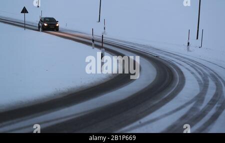 Marktoberdorf, Germania. 27th Feb, 2020. Le tracce di pneumatici appaiono su una strada coperta da neve. Credito: Karl-Josef Hildenbrand/Dpa/Alamy Live News Foto Stock