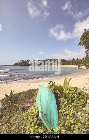 Immagine stilizzata di colore retrò di una spiaggia tropicale con una piccola barca. Foto Stock