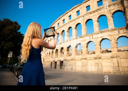 Bella giovane donna turista scattare foto dell'arena romana a Pula croazia Foto Stock