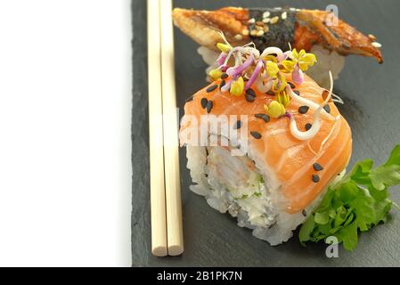 piatti tradizionali giapponesi maki e sushi serviti su pietra nera. deliziosa cena o pranzo per una persona. isolato su bianco per il menu Foto Stock