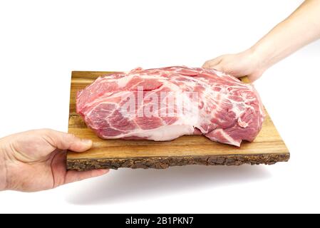 Fresco collo di maiale crudo su tagliere di legno isolato su bianco. Tagliere a mano maschio con carne di maiale. Foto Stock