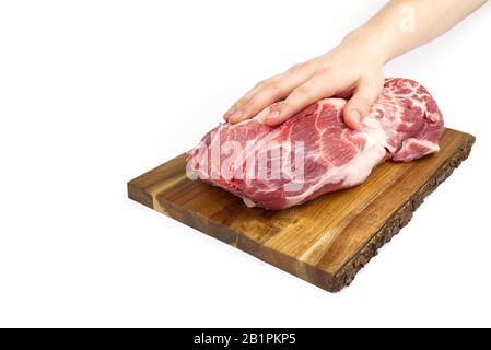 Fresco collo di maiale crudo su tagliere di legno isolato su bianco. Tagliere a mano maschio con carne di maiale. Foto Stock