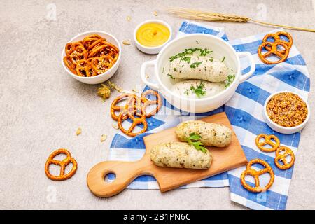 Set Oktoberfest. Salsiccia bianca wessswurst, pretzel, senape, spikelets di grano, luppolo. Cucina tradizionale tedesca, cibo festival. Ciotole, tovagliolo di lino, Foto Stock