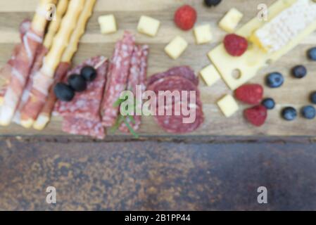Bokeh fondo di Antipasti a base Di Carne e formaggio con prosciutto, parmigiano, formaggio blu, melone di Cantalupo e olive. Foto Stock