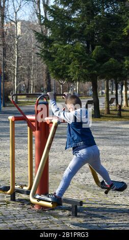 ragazzino che fa esercizi ginnici nel parco Foto Stock