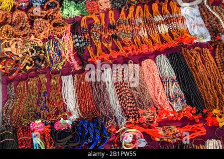Perline di preghiera dai colori vivaci in vendita sulla strada. Varanasi. India Foto Stock